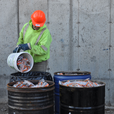 GFL staff empties full pails of batteries into consolidation drums