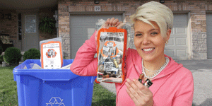 A resident holds up her battery recycling bag filled with household batteries
