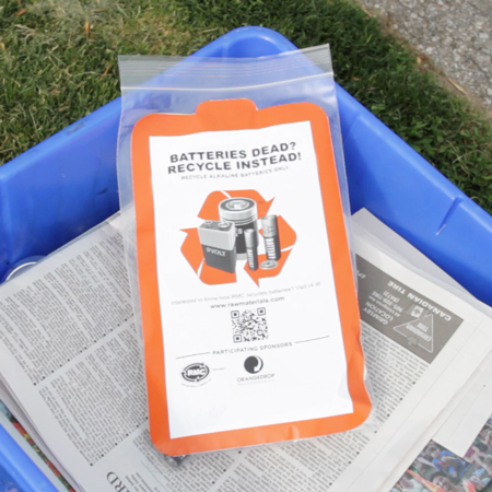 A battery recycling bag sits inside a blue box. Curbside battery collections are provided by many Ontario municipalities at certain times of the year. Batteries should never be placed loose inside a blue box outside of those collection periods.